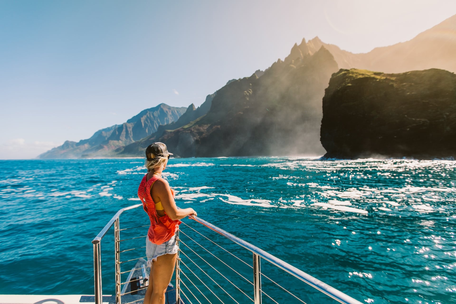 Woman enjoying the stunning coastal scenery on a private catamaran Kauai Na Pali Coast boat tour