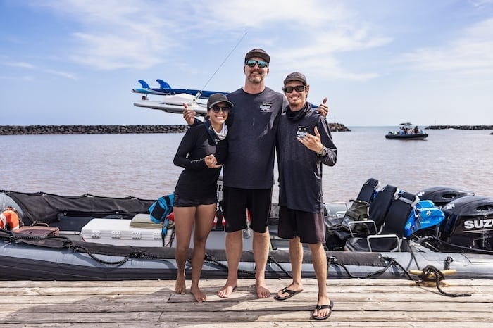 Crew members from Captain Andy's stand on a dock beside their raft.