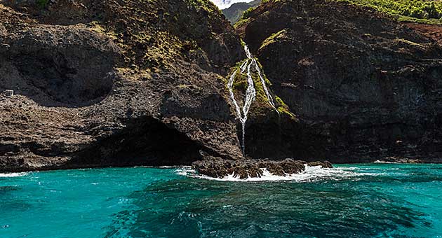 Passing a waterfall along Napali, zodiac Kauai.